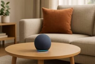 Echo Dot 5ª Geração: Vale a Pena? Descubra Agora 13 Echo Dot 5ª geração sobre uma mesa de madeira em uma sala moderna, com sofá cinza e almofadas coloridas ao fundo, iluminada por luz natural.